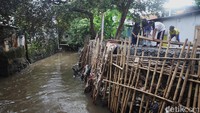 Warga beraktivitas di samping tanggul Kali Krukut di Petogogan, Jakarta, Rabu (12/11/2025).
