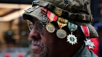 Seorang veteran mengenakan medali di topinya saat berpartisipasi dalam parade Hari Veteran. REUTERS/Brendan McDermid