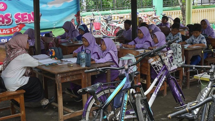 Seorang guru melihat atap ruang kelas ambruk di Sekolah Dasar Negeri Plosogenuk 1, Kecamatan Perak, Kabupaten Jombang, Jawa Timur, Rabu (12/11/2025). Sebanyak 60 siswa kelas VI terpaksa belajar di parkiran, ruang Perpustakaan dan UKS disebabkan atap ruang kelas ambruk. ANTARA FOTO/Syaiful Arif