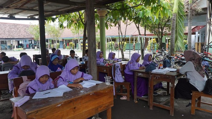 Seorang guru melihat atap ruang kelas ambruk di Sekolah Dasar Negeri Plosogenuk 1, Kecamatan Perak, Kabupaten Jombang, Jawa Timur, Rabu (12/11/2025). Sebanyak 60 siswa kelas VI terpaksa belajar di parkiran, ruang Perpustakaan dan UKS disebabkan atap ruang kelas ambruk. ANTARA FOTO/Syaiful Arif
