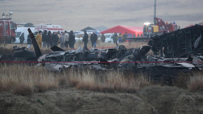 A member of emergency services works at the site of the Turkish C-130 military cargo plane crash near the Azerbaijani border, in Sighnaghi municipality, Georgia, November 12, 2025. REUTERS/Irakli Gedenidze