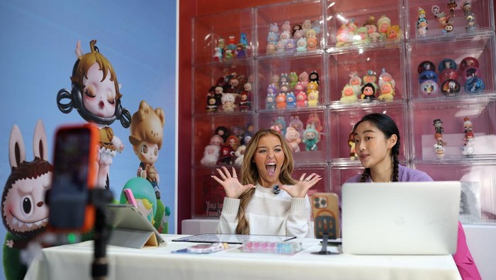 A staff member arranges some POP MART LABUBU THE MONSTERS dolls on a window shop ahead of an AliExpress and Pop Mart livestream shopping show on Singles' Day at a pop-up store in London, Britain, November 11, 2025. REUTERS/Isabel Infantes