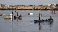 Warga Palestina memancing ikan di pelabuhan Kota Gaza saat gencatan senjata antara Israel dan Hamas, Rabu (12/11/2025). Kesempatan langka ini dimanfaatkan untuk memenuhi kebutuhan pangan keluarga. REUTERS/Mahmoud Issa