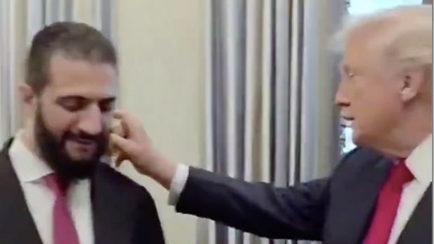 Presiden AS Donald Trump memberikan hadiah parfum dan menyemprotkan langsung kepada Presiden Suriah Ahmad Al Sharaa. (Tangkapan Layar X/@abhijitmajumder)