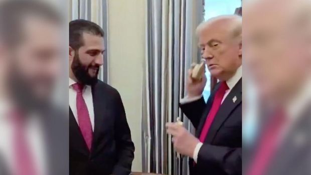 Presiden AS Donald Trump memberikan hadiah parfum dan menyemprotkan langsung kepada Presiden Suriah Ahmad Al Sharaa. (Tangkapan Layar X/@abhijitmajumder)