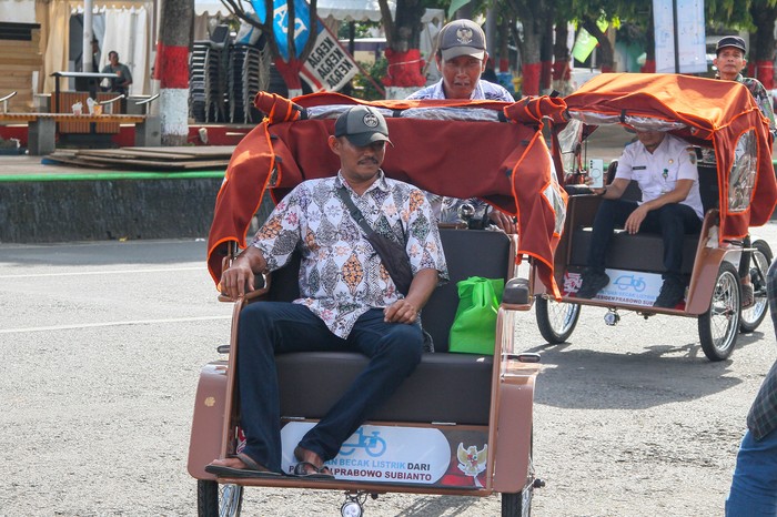 Warga menaiki becak listrik bantuan dari Presiden Prabowo Subianto di Alun-alun Indramayu, Jawa Barat, Kamis (13/11/2025). Presiden Prabowo melalui Yayasan Gerakan Solidaritas Nasional bersama Badan Percepatan Pengentasan Kemiskinan (BP-Taskin) memberikan bantuan becak listrik kepada tukang becak lansia sebanyak 100 unit di Indramayu untuk membantu mengurangi kemiskinan terutama warga yang berprofesi sebagai tukang becak usia lanjut. ANTARA FOTO/Dedhez Anggara