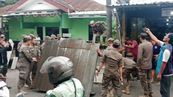 Satpol PP Kota Depok menertibkan bangunan liar di sepanjang jalan menuju Stasiun Depok Lama.  (Dok istimewa).