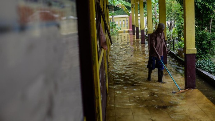 Penjaga sekolah membersihkan sisa banjir di SD Negeri Pamarican 2, Kota Serang, Banten, Kamis (13/11/2025). Sebanyak dua sekolah dasar di daerah tersebut terdampak banjir sejak Senin (10/11) akibat posisi sekolah yang lebih rendah dari jalan disertai buruknya saluran drainase sehingga mengakibatkan kegiatan belajar mengajar terpaksa dilaksanakan secara daring. ANTARA FOTO/Muhammad Bagus Khoirunas/bar