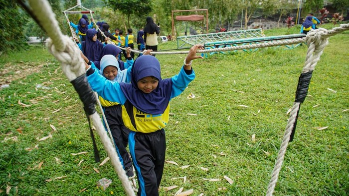 Siswa TK bermain saat kegiatan belajar luar kelas di kawasan wisata Bumi Perkemahan Glagah Arum di Kecamatan Senduro, Lumajang, Jawa Timur, Kamis (13/11/2025). Kawasan glamping yang dikelola Pramuka Kwartir Cabang Lumajang dan berdiri di atas lahan seluas 10,4 hektare milik Perhutani ini dikelilingi lanskap megah Gunung Semeru dan akan dikembangkan sebagai destinasi wisata edukasi, ekonomi, dan pariwisata unggulan daerah. ANTARA FOTO/Irfan Sumanjaya/bar