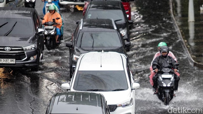 Warga melintasi pedestrian Jl Sudirman, Jakarta, menggunakan payung saat hujan deras, Kamis (13/11/2025). BMKG mengimbau masyarakat untuk meningkatkan kewaspadaan terhadap potensi cuaca ekstrem dalam sepekan ke depan.