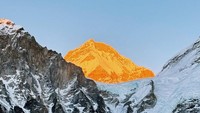 Pemandangan puncak Everest terlihat berwarna oranye sendiri. Ini pas sunset. Kebetulan kita kelar dari EBC sekitar jam 5 sore karena dia paling tinggi di antara yang lain, jadi dia yang paling terakhir disinari matahari. Aslinya lebih gila lagi. Aku sampai gak bisa describe. Benar-benar hal yang belum pernah aku lihat sebelumnya secara langsung, jelasnya. Foto: Instagram @angelagilsha