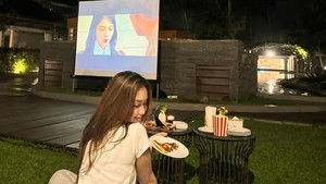 Ayu Ting Ting movie time di halaman rumah dengan menggunakan proyektor. Foto: Instagram Ayu Ting Ting