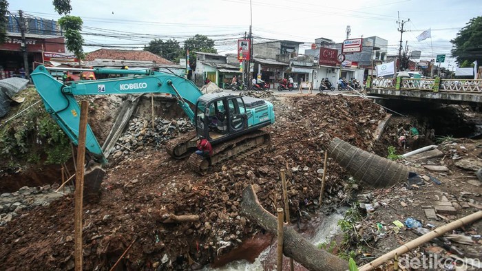 Petugas mengerjakan proyek rehabilitasi bangunan BCB 3 di Jalan Raya Jembatan Serong, Cipayung, Depok, Jumat (14/11/2025). Sebelumnya aliran kali di kolong jembatan ini memiliki bendungan yang telah jebol akibat derasnya aliran kali.