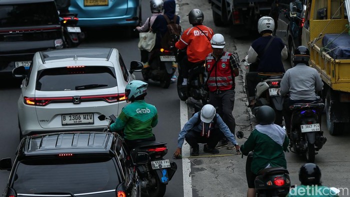Pekerja tampak mengukur ruas Jalan D.I Panjaitan, Jakarta, Jumat (14/11/2025).
 Dinas SDA DKI Jakarta melalui Sudin SDA Jakarta Timur mengerjakan pembangunan Saluran Jacking dan Crossing di ruas jalan tersebut.