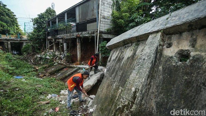 Pekerja menyelesaikan pembongkaran tanggul sisi kali Krukut, Depok, Jumat (14/11/2025).