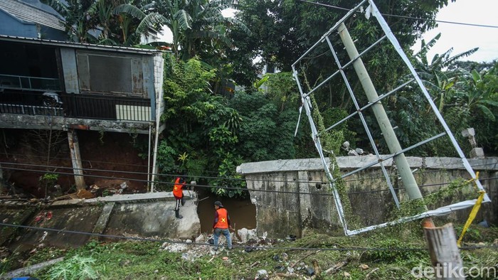 Pekerja menyelesaikan pembongkaran tanggul sisi kali Krukut, Depok, Jumat (14/11/2025).