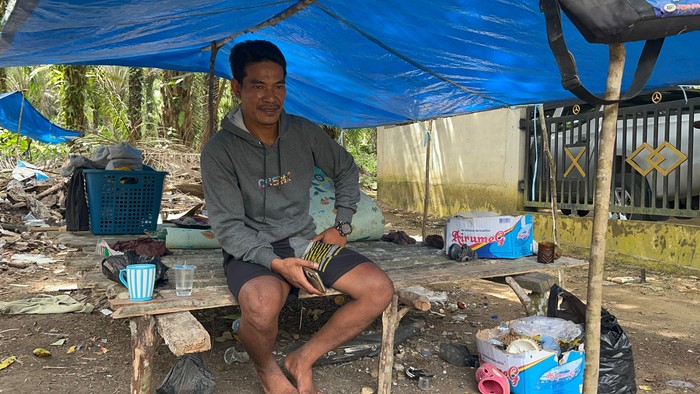 Tumenggung Joni, pemimpin kelompok Orang Rimba di Desa Mentawak, Merangin, duduk di atas sudung yang berada di samping rumahnya