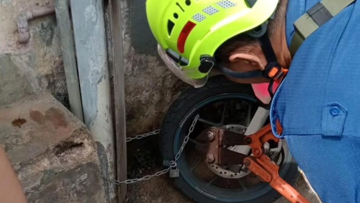 Damkar Bogor membantu melepaskan gembok motor yang terkunci.
