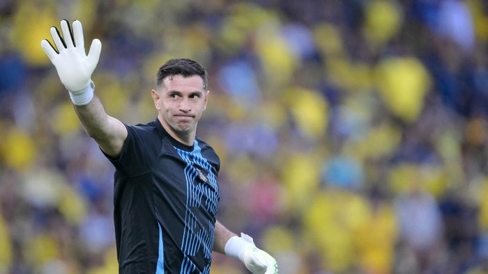 (FILES) Argentinas goalkeeper Emiliano Martinez waves during a warmup ahead of the 2026 FIFA World Cup South American qualifiers football match between Ecuador and Argentina at the Monumental Banco Pichincha Stadium in Guayaquil, Ecuador on September 9, 2025. Goalkeeper for the world champion team, Emiliano Dibu Martnez is not among those called up and appears to be the big name missing from Argentinas friendly football match against Angola in Luanda on November 14, 2025. (Photo by Rodrigo BUENDIA / AFP)