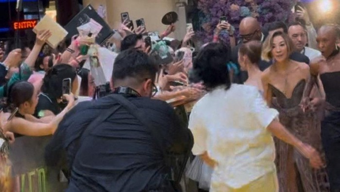 A fan who jumped a barrier runs towards Ariana Grande as she walks the carpet alongside cast members Michelle Yeoh and Cynthia Erivo during the Wicked: For Good movie premiere in Singapore, November 13, 2025 in this screen grab obtained from social media video. @tacotrvck_vb via X/via REUTERS  THIS IMAGE HAS BEEN SUPPLIED BY A THIRD PARTY. MANDATORY CREDIT. NO RESALES. NO ARCHIVES.  VERIFICATION LINES: - Location verified by exterior structure, design, signage, and event information - Date verified by original file metadata