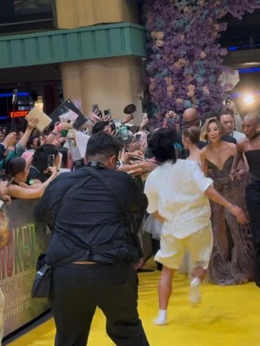 A fan who jumped a barrier runs towards Ariana Grande as she walks the carpet alongside cast members Michelle Yeoh and Cynthia Erivo during the 'Wicked: For Good' movie premiere in Singapore, November 13, 2025 in this screen grab obtained from social media video. @tacotrvck_vb via X/via REUTERS  THIS IMAGE HAS BEEN SUPPLIED BY A THIRD PARTY. MANDATORY CREDIT. NO RESALES. NO ARCHIVES.  VERIFICATION LINES: - Location verified by exterior structure, design, signage, and event information - Date verified by original file metadata