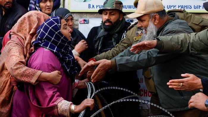 A woman urges Indian security personnel to release the body of her brother, Muhammad Shafi Parry, who was killed in an explosion at a police station in Srinagar, Indian Kashmir, November 15, 2025. REUTERS/Sharafat Ali REFILE - QUALITY REPEAT