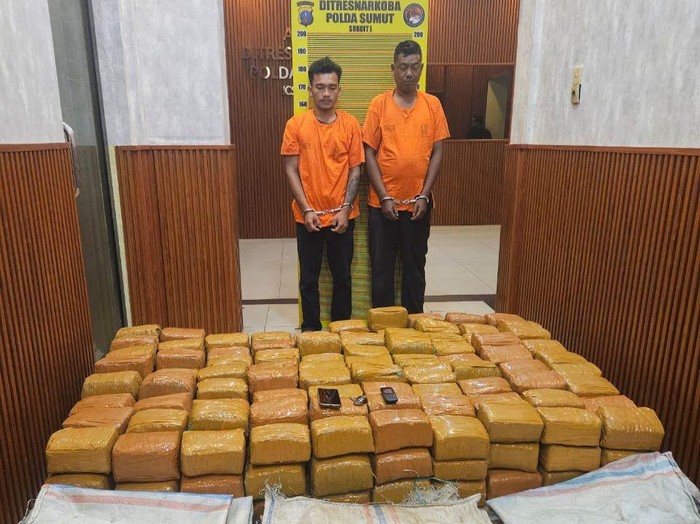Kedua pelaku dan 255 kg ganja saat diamankam di kantor polisi.