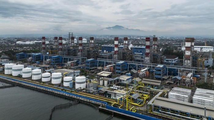 Nelayan memindahkan ikan hasil tangkapan dengan latar belakang Pembangkit Listrik Tenaga Gas dan Uap (PLTGU) Tambaklorok di Semarang, Jawa Tengah, Sabtu (15/11/2025). Kementerian Energi dan Sumber Daya Mineral (ESDM) mencatat terdapat tren peningkatan produksi listrik dari energi baru dan energi terbarukan (EBT) atau listrik bersih dari 3,72 Terawatt jam (TWh) pada Januari 2025 menjadi 37,48 TWh pada Oktober 2025. ANTARA FOTO/Aprillio Akbar/rwa.