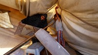 Meski kondisi ini menguji fisik dan mental, solidaritas terlihat jelas ketika tetangga saling membantu menstabilkan tenda dan membagikan peralatan sederhana untuk mempercepat perbaikan. REUTERS/Mahmoud Issa