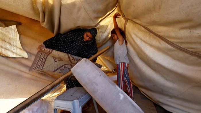 Hujan deras dan angin kencang yang melanda Jalur Gaza bagian tengah, Minggu (16/11/2025), kembali menambah kesulitan bagi para pengungsi Palestina. Tenda-tenda yang menjadi tempat tinggal sementara mereka rusak diterjang cuaca buruk, memaksa warga untuk bertahan dan segera melakukan perbaikan di tengah hujan yang tak henti. REUTERS/Mahmoud Issa