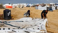 Tenda-tenda yang menjadi tempat tinggal sementara mereka rusak diterjang cuaca buruk, memaksa warga untuk bertahan dan segera melakukan perbaikan di tengah hujan yang tak henti. REUTERS/Mahmoud Issa