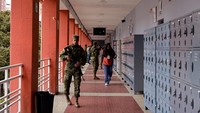 Personel militer berjaga-jaga saat warga memberikan suara, di sebuah stasiun pengumpulan suara di Quito, Ekuador. REUTERS/Karen Toro