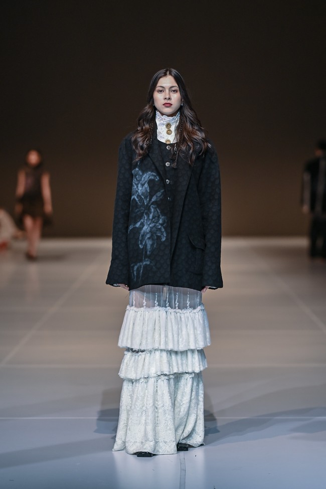 Koleksi ini dibuka dengan deretan busana serba putih—sebuah simbol dari kanvas bersih yang mewakili kerawanan, kejujuran, dan ruang batin yang belum tersentuh. Warna putih tersebut menjadi landasan visual yang kontras namun murni, menandai perjalanan introspektif yang ingin dihadirkan Tanah Le Saé. (Foto: Dok. JFW)