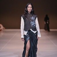 Koleksi ini menggabungkan kain tenun tangan dengan rok panjang drapery signature mereka, paduan yang menciptakan kontras antara ketegangan dan ketenangan. Draping lembut mengalir mengikuti kontur tubuh, sementara tekstur tenun memberikan bobot visual dan kedalaman. (Foto: Dok. JFW)