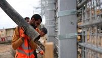 Para pekerja tengah membangun tembok beton. Dari sisi Israel utara, pembangunan tembok ini terlihat jelas dan memicu pengawasan ketat oleh pihak berwenang. REUTERS/Shir Torem