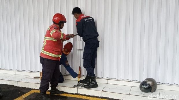 Petugas Damkar Ciamis sedang berusaha membuka rolling door minimarket yang macet. Petugas Damkar Ciamis sedang berusaha membuka rolling door minimarket yang macet.