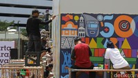 Sejumlah seniman menggambar mural saat Jakarta Mural Festival 2025 di Taman Ismail Marzuki (TIM), Cikini, Jakarta, Minggu (16/11/2025).