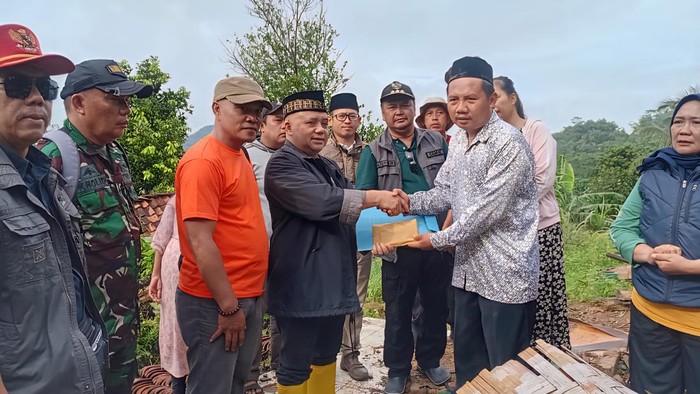 Unang Sudarma, Ketua Baznas Kabupaten Sukabumi mewakili Bupati Sukabumi memberikan bantuan.