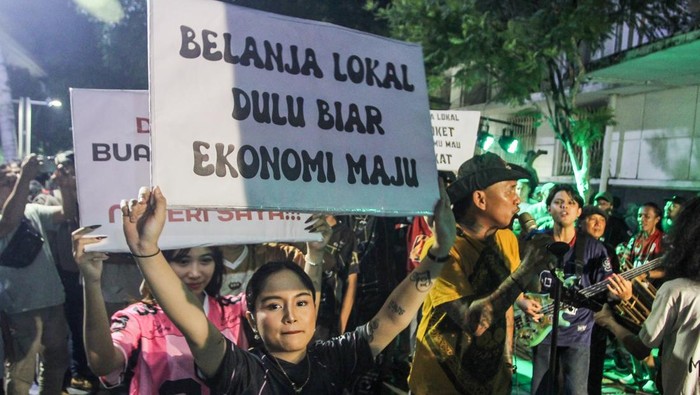 Massa aksi dari Citayam All Star membawa poster dukungan produk UMKM konveksi pada Aksi Seni di Kota Tua, Jakarta, Minggu (16/11/2025). Kegiatan yang diselenggarakan pelaku UMKM Konveksi Sinergi Adv Nusantara bersama musisi serta para konten kreator Citayam All Star itu sebagai bentuk terima kasih kepada pemerintah karena sudah memberhentikan impor pakaian bekas ilegal. ANTARA FOTO/Naufal Khoirulloh/YU