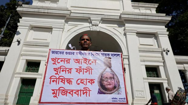 BANGLADESH-POLITICS/HASINA Seorang pria memegang poster di depan pengadilan yang menuntut hukuman mati menjelang putusan atas tuduhan kejahatan terhadap kemanusiaan atas tindakan keras mematikan terhadap protes mahasiswa pada tahun 2024 terhadap Perdana Menteri terguling Sheikh Hasina, di Dhaka, Bangladesh, 17 November 2025. REUTERS/Mohammad Ponir Hossain