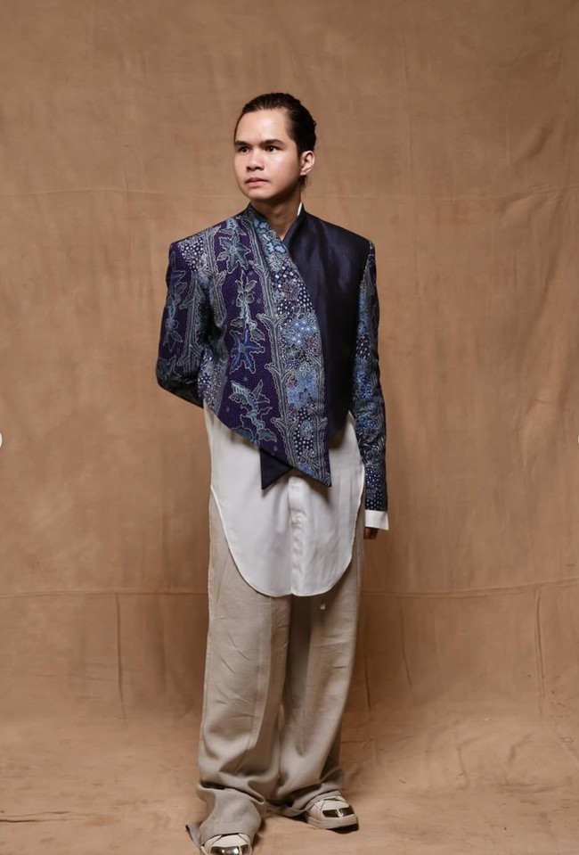 Sedangkan Dul mengenakan atasan bernuansa batik dengan potongan asimetris yang memberi kesan kontemporer. Warna biru keunguan dipadukan dengan detail motif tradisional memberikan kesan klasik namun tetap modern. Dul juga terlihat mengenakan inner putih panjang dengan garis potongan melengkung, dipasangkan celana longgar berwarna krem. Foto: Instagram/@thebridedept