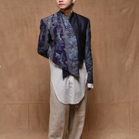 Sedangkan Dul mengenakan atasan bernuansa batik dengan potongan asimetris yang memberi kesan kontemporer. Warna biru keunguan dipadukan dengan detail motif tradisional memberikan kesan klasik namun tetap modern. Dul juga terlihat mengenakan inner putih panjang dengan garis potongan melengkung, dipasangkan celana longgar berwarna krem. Foto: Instagram/@thebridedept