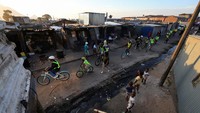 Peserta tur berpemandu menjelajahi area Langa menggunakan sepeda. Aktivitas ini membantu mengurangi emisi transportasi yang menyumbang hampir 60% polusi kota Cape Town. Foto: REUTERS/Esa Alexander