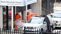 Petugas bersertifikat penanganan asbes melakukan remediasi di Black Mountain School, Canberra, Australia, Senin (17/11/2025). Hampir 70 sekolah publik ditutup sementara setelah ditemukan potensi kontaminasi asbes pada pasir berwarna yang dipakai untuk kegiatan belajar. Lukas Coch/AAP/via REUTERS