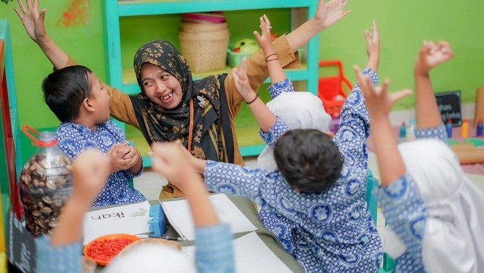 Ilustrasi guru mengajar siswa di kelas.