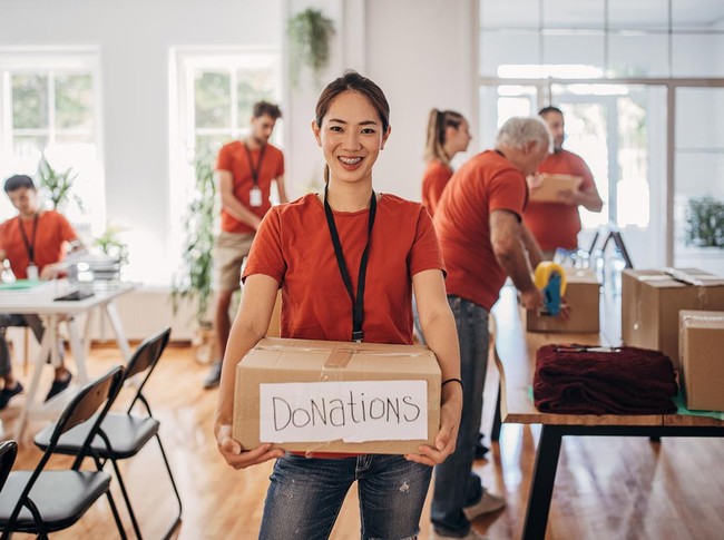 Portrait of volunteer holding donation box with goods for people in need