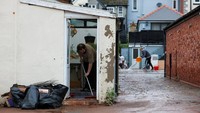 Seorang pria membersihkan bagian dalam rumah yang terdampak banjir parah akibat Badai Claudia di Monmouth, Wales, Minggu (16/11/2025). Banjir merusak sejumlah permukiman setelah hujan ekstrem mengguyur wilayah tersebut. REUTERS/Isabel Infantes