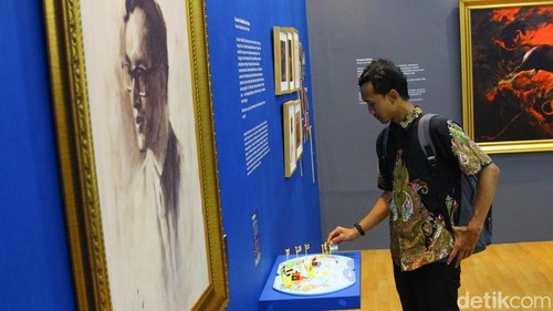 Pengunjung mengamati salah satu lukisan dalam pameran “Basoeki Abdullah dan Perjalanannya” yang digelar di MRT Fatmawati, Jakarta, Senin (17/11/2025).