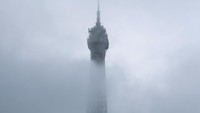 Menara Eiffel tampak tertutup kabut pagi yang menyelimuti Paris, Prancis, Minggu (16/11/2025), menciptakan suasana dramatis bagi para wisatawan. REUTERS/Stephanie Lecocq