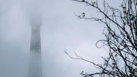 Meski puncaknya sempat tak terlihat, keindahan siluet Menara Eiffel tetap menarik perhatian turis. REUTERS/Stephanie Lecocq